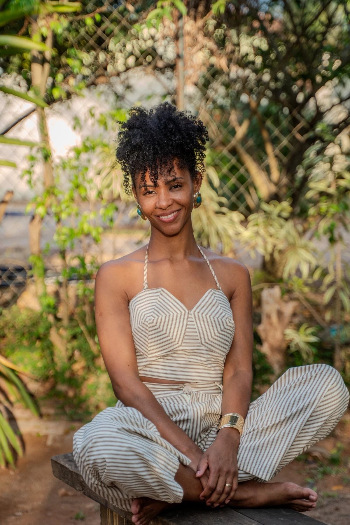 Érika sorrindo, sentada ao ar livre